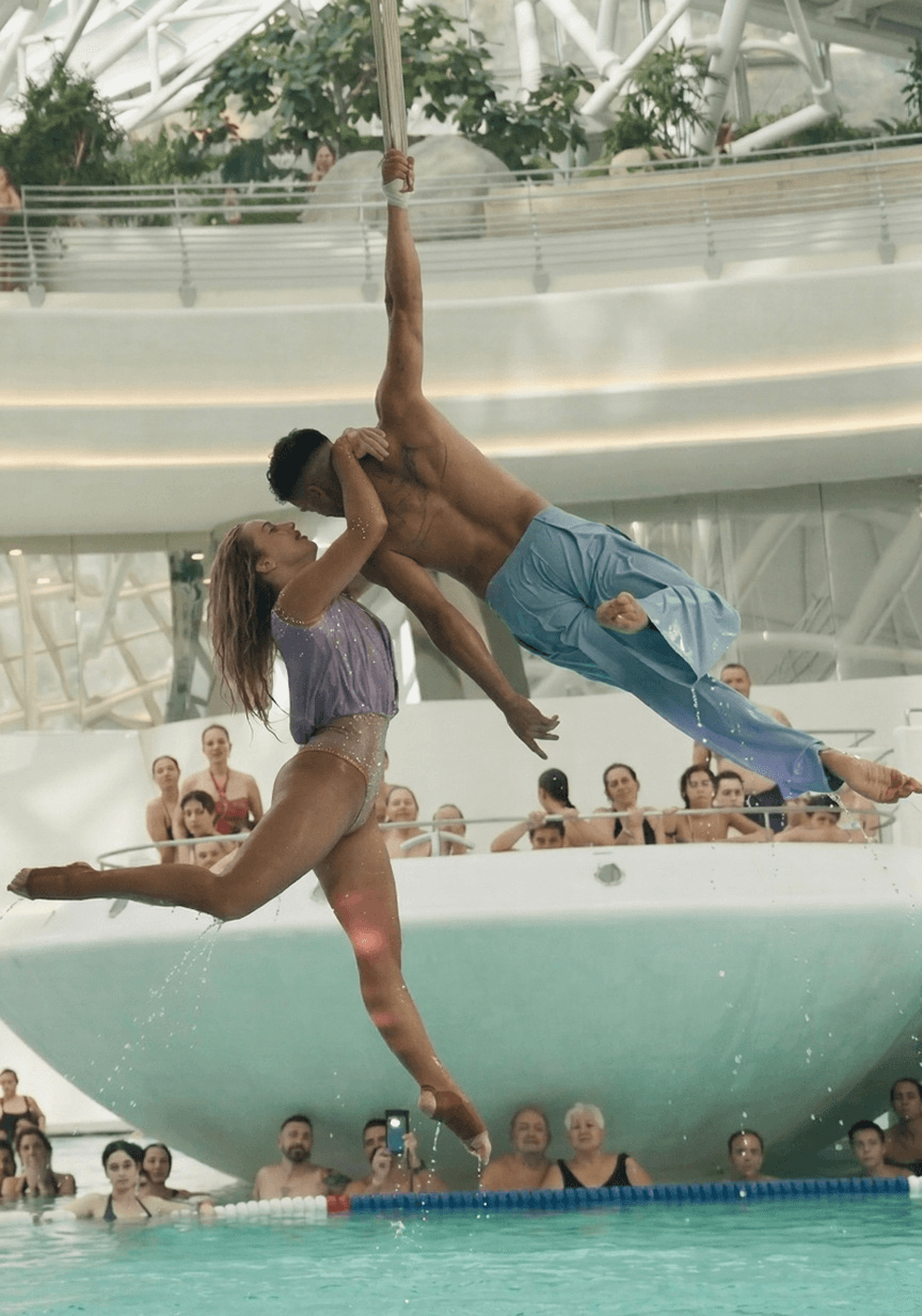 Dúo acrobático en estrabos aéreos sobre una piscina